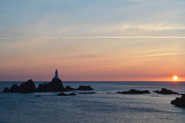 Image of Seymour Tower with cloudy sky and reflection in pool with ripples. Jersey, Channel Islands. Selective focus