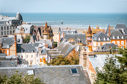 Top view of Trouville city with rooftops of luxury houses and ocean on the background in France