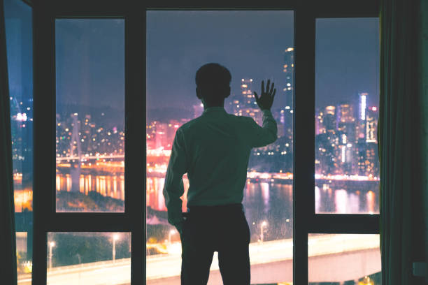 istock Businessman standing by window at night,Hand touching window 1062519606
