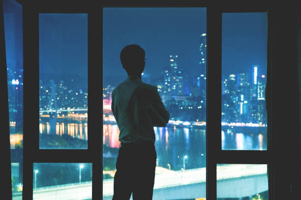 istock Businessman standing by window at night 1062519656