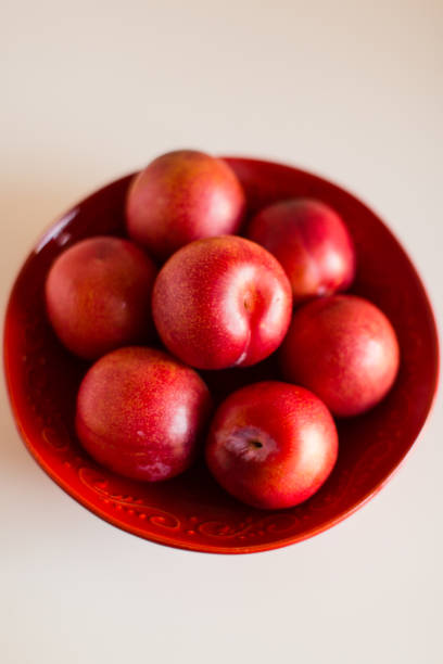 istock Red Plums in a Red Bowl 1062524212