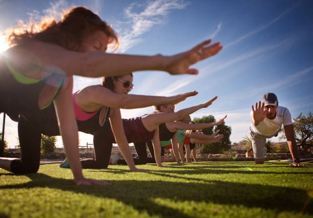 Sunshine Boot Camp A mixed group of people exercising in the sun. fitness boot camp stock pictures, royalty-free photos & images