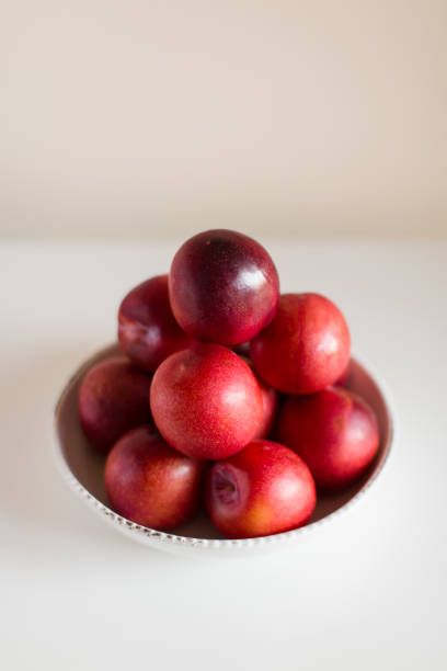 istock Red Plums in a White Bowl 1062529884