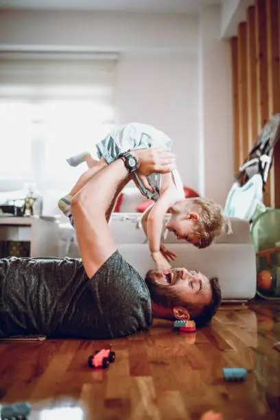 Father Having Fun With Baby Son In Living Room