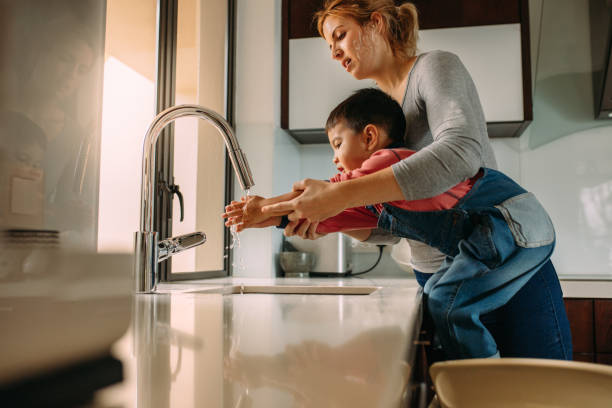 istock Son washing hands with mother in the sink 1062536208