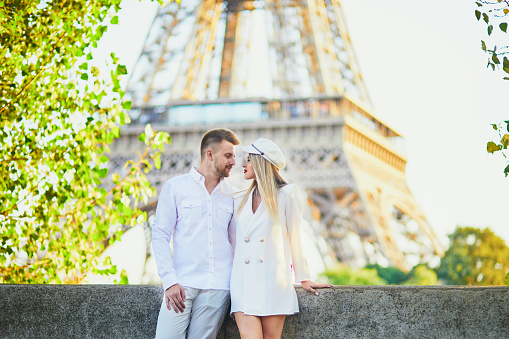 Romantic couple having a date near the Eiffel tower. Tourists in Paris enjoying the city