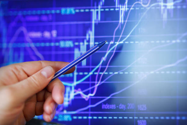 trader's chart of a rise or fall in the exchange rate indicates a hand with a pen - fotografia de stock