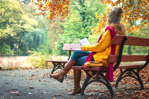 Woman wearing sweater, jeans and leather boots.