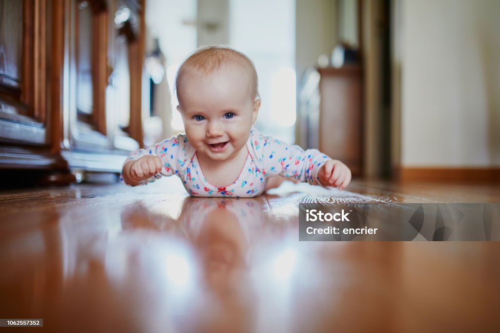 Baby girl learning to crawl Baby girl learning to crawl. Happy healthy little child on the floor. Infant kid at home Baby - Human Age Stock Photo