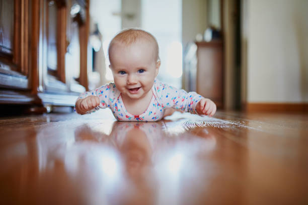 Baby girl learning to crawl stock photo