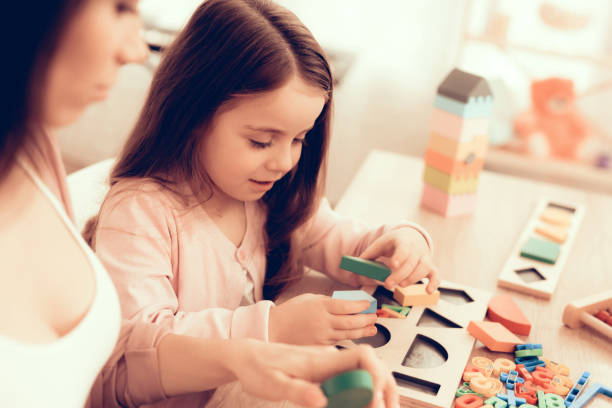 istock Girl Plays Developing Board Game for Children. 1062557422
