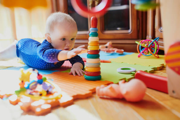 Baby girl playing with toys on the floor Baby girl playing with toys on the floor. Happy healthy little child at home nursery bedroom photos stock pictures, royalty-free photos & images