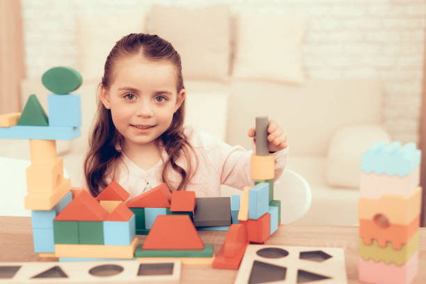 istock Little Girl Playing with Cubes on Table at Home. 1062557536