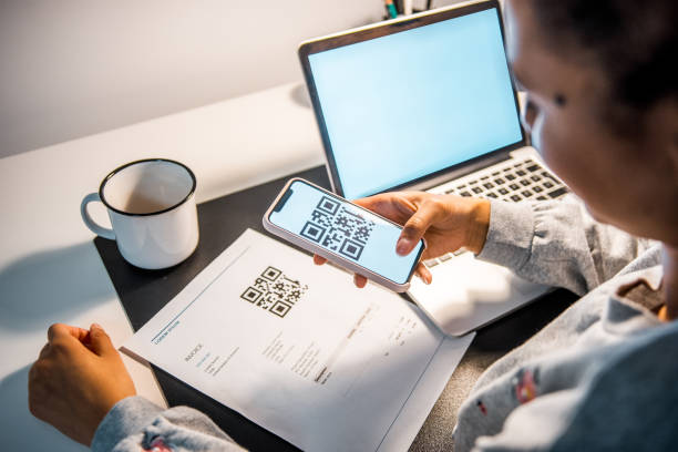 istock African woman scanning the QR code on a bill with a smart phone 1062558576