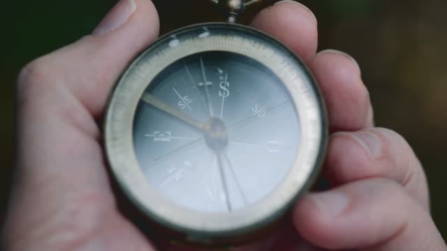 Close up on old compass instrument in hand. shot in slow motion