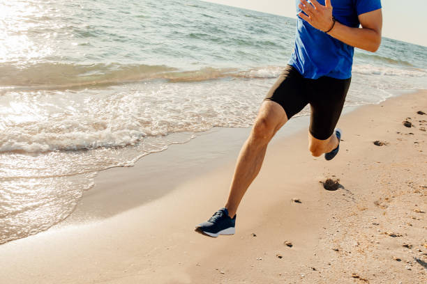 istock legs athlete runner run along beach leaving footprints in sand 1062560162