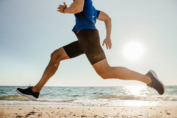 istock close-up feet runner man running on beach in sunlight 1062560170