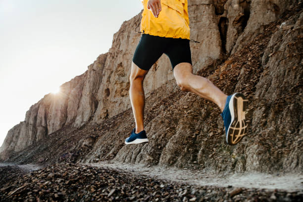 istock man athlete running on mountain trail in sunlight 1062562364