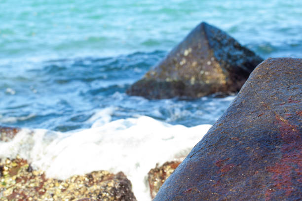 Waves crushing on a rocky beach in sunny day
