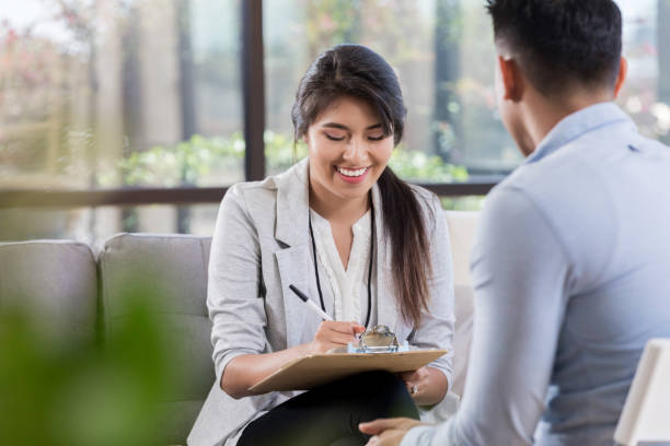 istock Cheerful counselor takes notes during patient appointment 1062564536
