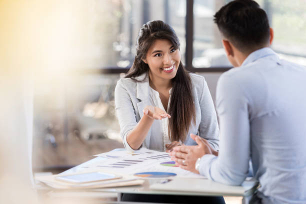 istock Cheerful businesswoman discusses statistical data with coworker 1062564580