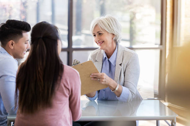 istock Cheerful counselor discusses forms with couple 1062564600