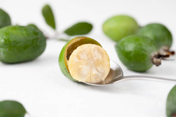 Fresh raw feijoa fruit on a spoon on white The preparation of wholesome food, products for the treatment and diet of beauty pineapple guava stock pictures, royalty-free photos & images