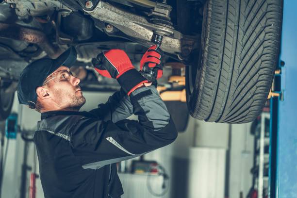 Mechanic Suspension Fix Caucasian Car Mechanic Adjusting Tension in Vehicle Suspension Element. Professional Automotive Service. repairperson occupation stock pictures, royalty-free photos & images