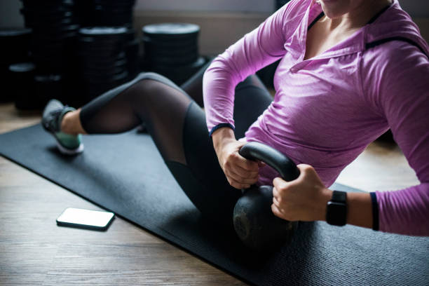 istock Young woman exercising with a kettle bell on the exercise mat 1062570948