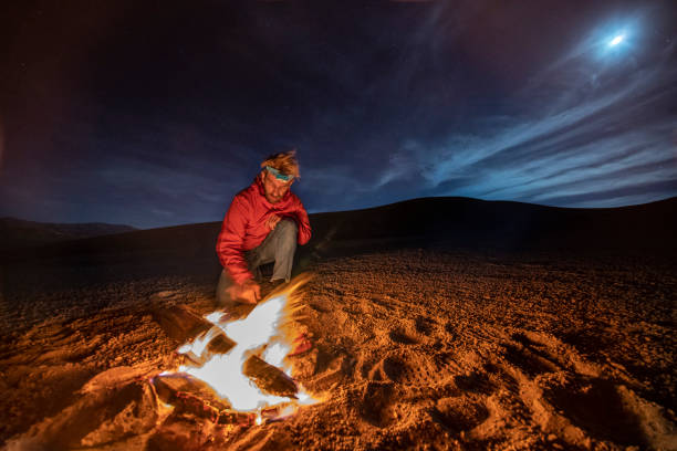 istock While looking for meteorites at Atacama Desert we made a stop for sleeping in the middle of the amazing Atacama Desert. One man on a camp fire under the full moon light on a starry night. Chile 1062575104