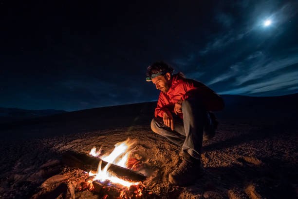 istock While looking for meteorites at Atacama Desert we made a stop for sleeping in the middle of the amazing Atacama Desert. One man on a camp fire under the full moon light on a starry night. Chile 1062575250