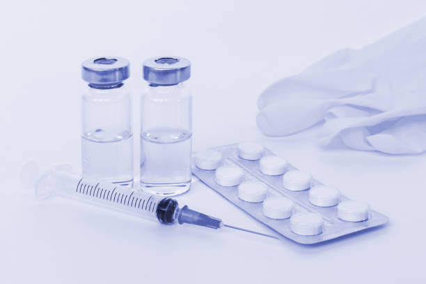 istock Set of syringe, two vials, tablets and gloves toned light blue 1062601734
