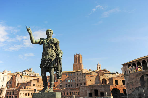 статуя императора траяна на улице fori imperiali, рим, италия - julius caesar стоковые фото и изображения