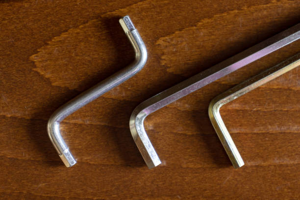 a set of three allen key-hex wrench on brown wooden background - screwdriver screw tighten fastener imagens e fotografias de stock