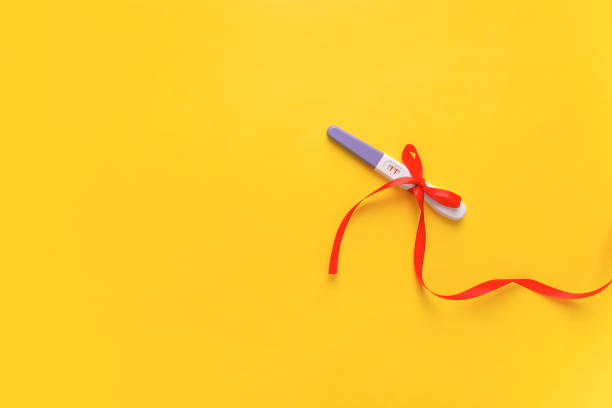 istock Pregnancy test on a yellow background. The result is positive. Two strips. 1062604486