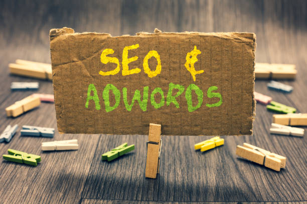 Writing note showing Seo and Adwords. Business photo showcasing Pay per click Digital marketing Google Adsense Clothespin holding paperboard important communicating message ideas.