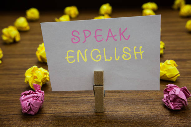 istock Handwriting text writing Speak English. Concept meaning Study another Foreign Language Online Verbal Courses Clothespin holding white paper note crumpled papers several tries mistakes. 1062609760