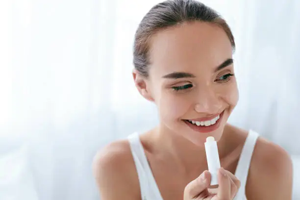 Lips Skin Care. Beautiful Woman Applying Lip Balm Portrait. Girl With Natural Makeup On Beauty Face. High Resolution