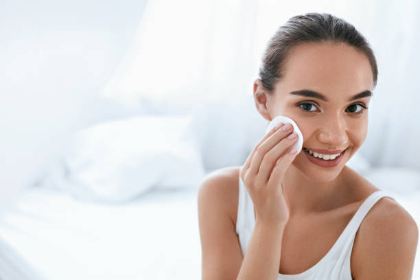 istock Makeup Remove. Girl Cleaning Face Skin With Cosmetic Pad 1062628172