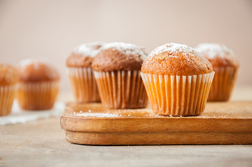 Tasty muffin closeup on a wooden board, selective focus.