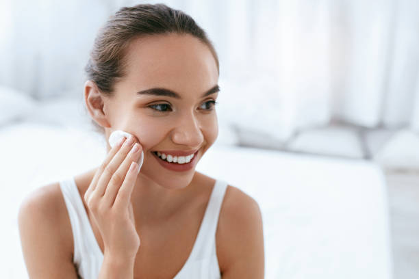 istock Makeup Remove. Girl Cleaning Face Skin With Cosmetic Pad 1062629844
