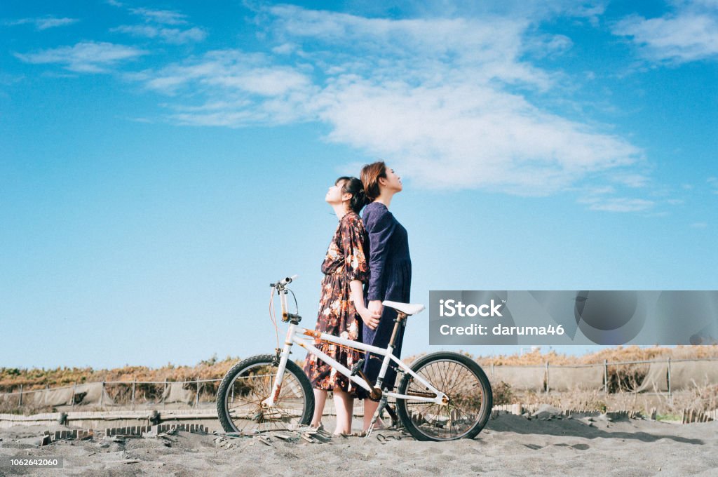 Girls standing at the beach. A girls standing at the beach. Cycling Stock Photo