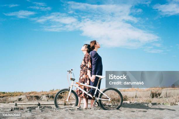 Girls Standing At The Beach Stock Photo - Download Image Now - Cycling, Forked Road, Friendship