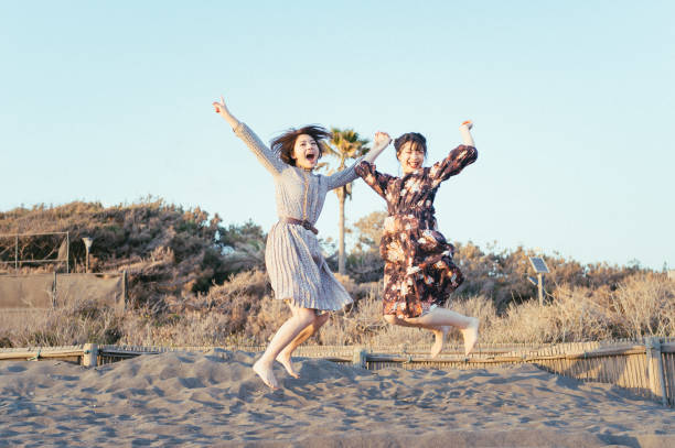 해변에서 점프 하는 여자. - jumping freedom women beach 뉴스 사진 이미지