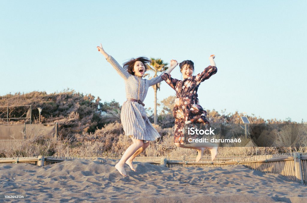 Girls jumping at the beach. Women Stock Photo