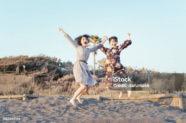 Girls Jumping At The Beach Stock Photo - Download Image Now - Women, Japanese Ethnicity, Friendship