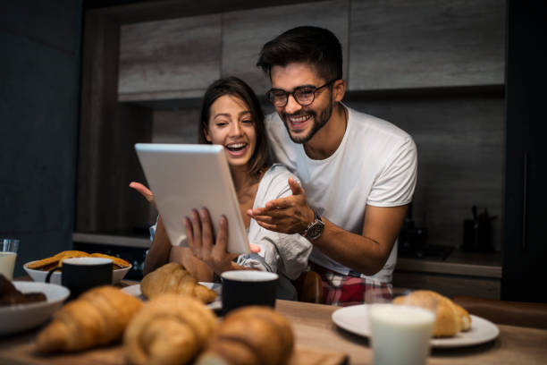 istock Young couple at home using digital tablet - Morning breakfast time 1062659794