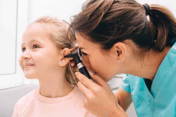 Smiling little girl having ear exam with otoscope Pediatrician examining little patient with otoscope, hearing exam of child ear exam stock pictures, royalty-free photos & images