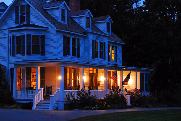 un hogar suburbano se enciende al atardecer - porch light fotografías e imágenes de stock