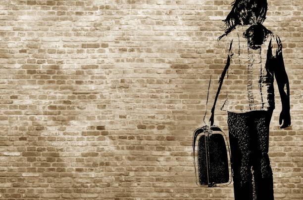 Graffiti/shadow on a brickwall showing a refugee girl walking with her suitcase Graffiti/shadow on a brickwall showing a refugee girl walking with her suitcase family photo on wall stock pictures, royalty-free photos & images